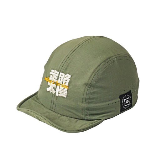 An olive green 5-panel cap with white and yellow embroidered Japanese text on the front and a black brand patch on the side, photographed on a clean white background.