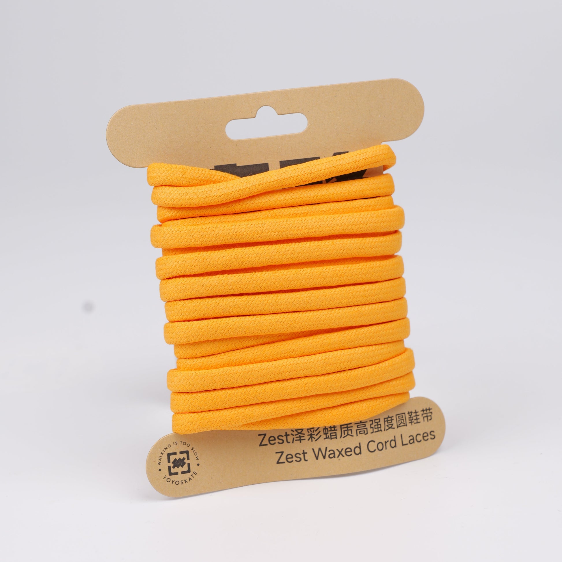 Bright orange Zest waxed cord laces on a cardboard hanger, photographed against a clean white background.