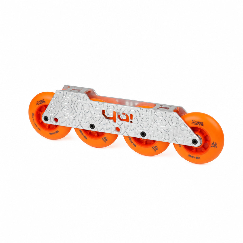 Sago inlineskating fra,es for flatland style with a silver aluminum featuring a textured pattern and orange 'YO!' branding, paired with four bright orange wheels, shown on a white background.