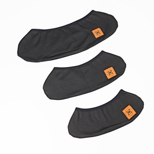 Three black whee covers arranged diagonally on a white background, each featuring a small orange square patch with a stylized logo.