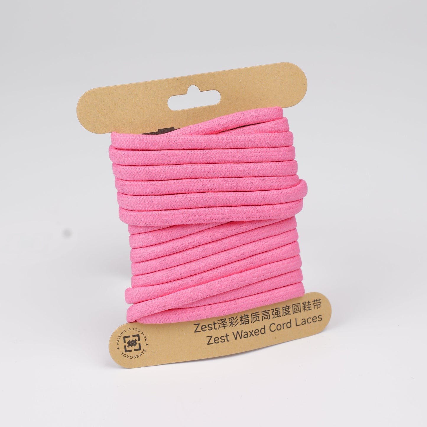 A spool of bright pink cord lace wrapped in a kraft cardboard hanger, photographed on a clean white background.
